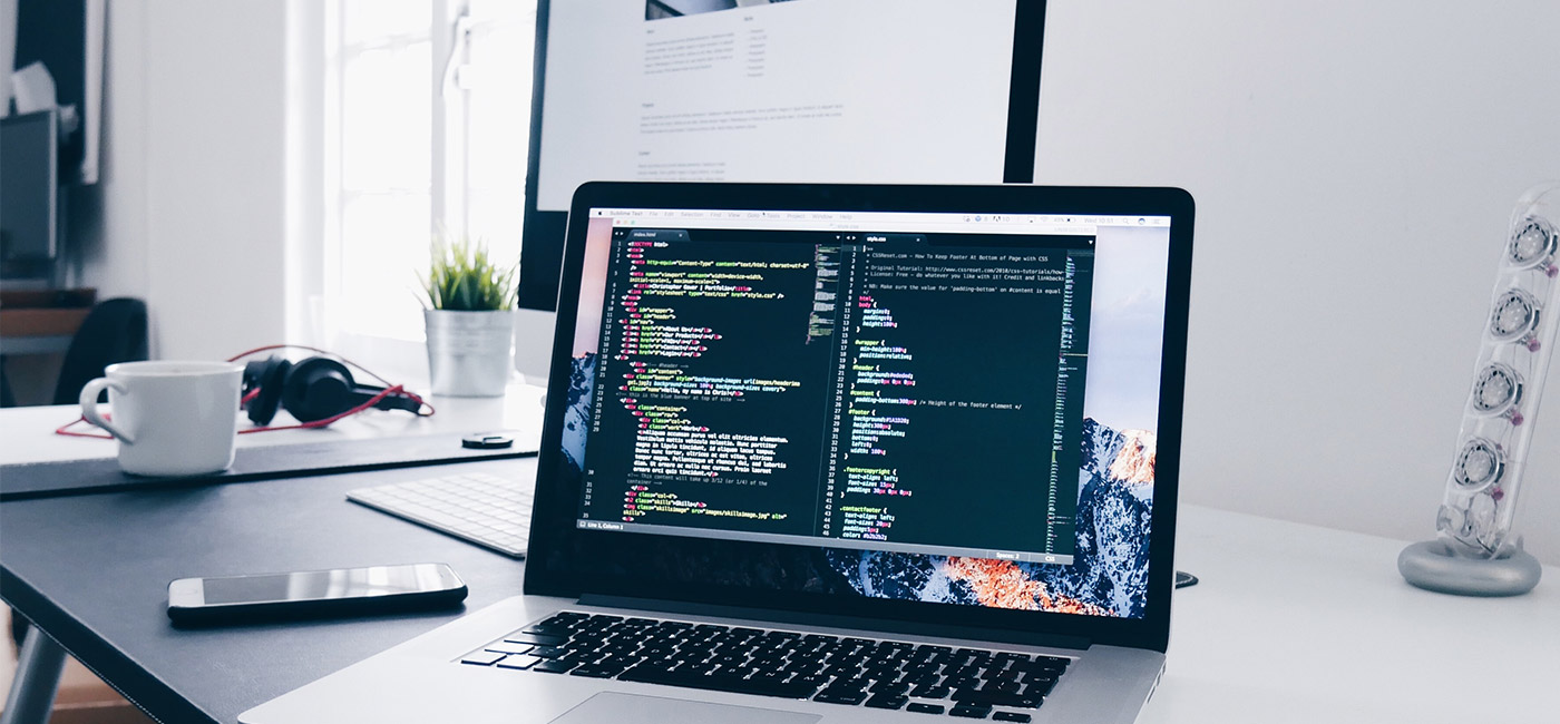 Website-Blog MacBook Pro on a desk with code on the screen.