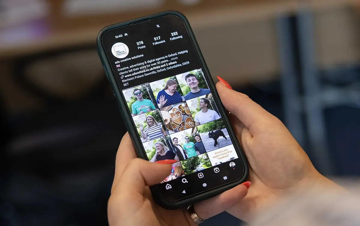 how_insta1webp Person holding a phone with Instagram feed on screen